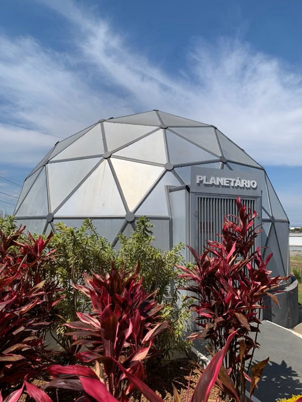 Geodesic dome planetarium surrounded by plants
